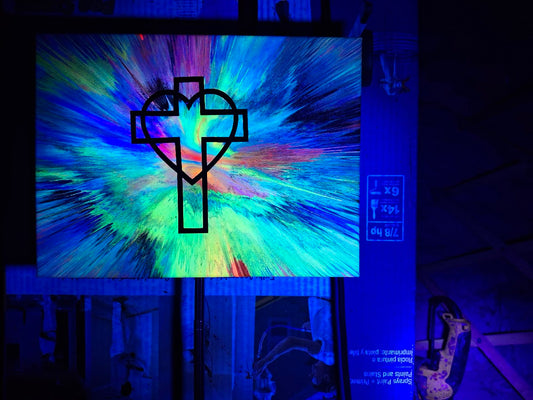 Colorful abstract design with a cross-like symbol on a screen in a dark room.