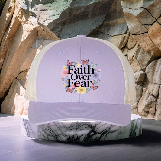 Divine Faith Armor™ “Faith Over Fear” Richardson 115R Low Pro Trucker Cap – embroidered Christian hat with adjustable mesh back for men and women Purple cap with 'Faith Over Fear' text and floral design against a stone wall background