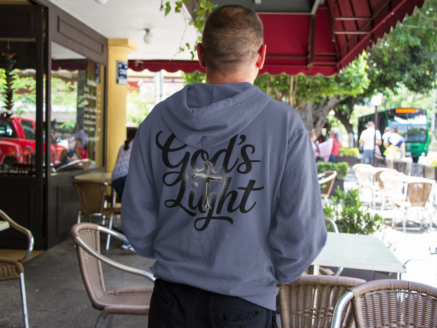 Divine Faith Armor™ GOD’S LIGHT hoodie with white script text and mirror-image cross design, faith-based Christian apparel for men, women, and youth Person wearing a hoodie with 'God's Light' text in an outdoor setting