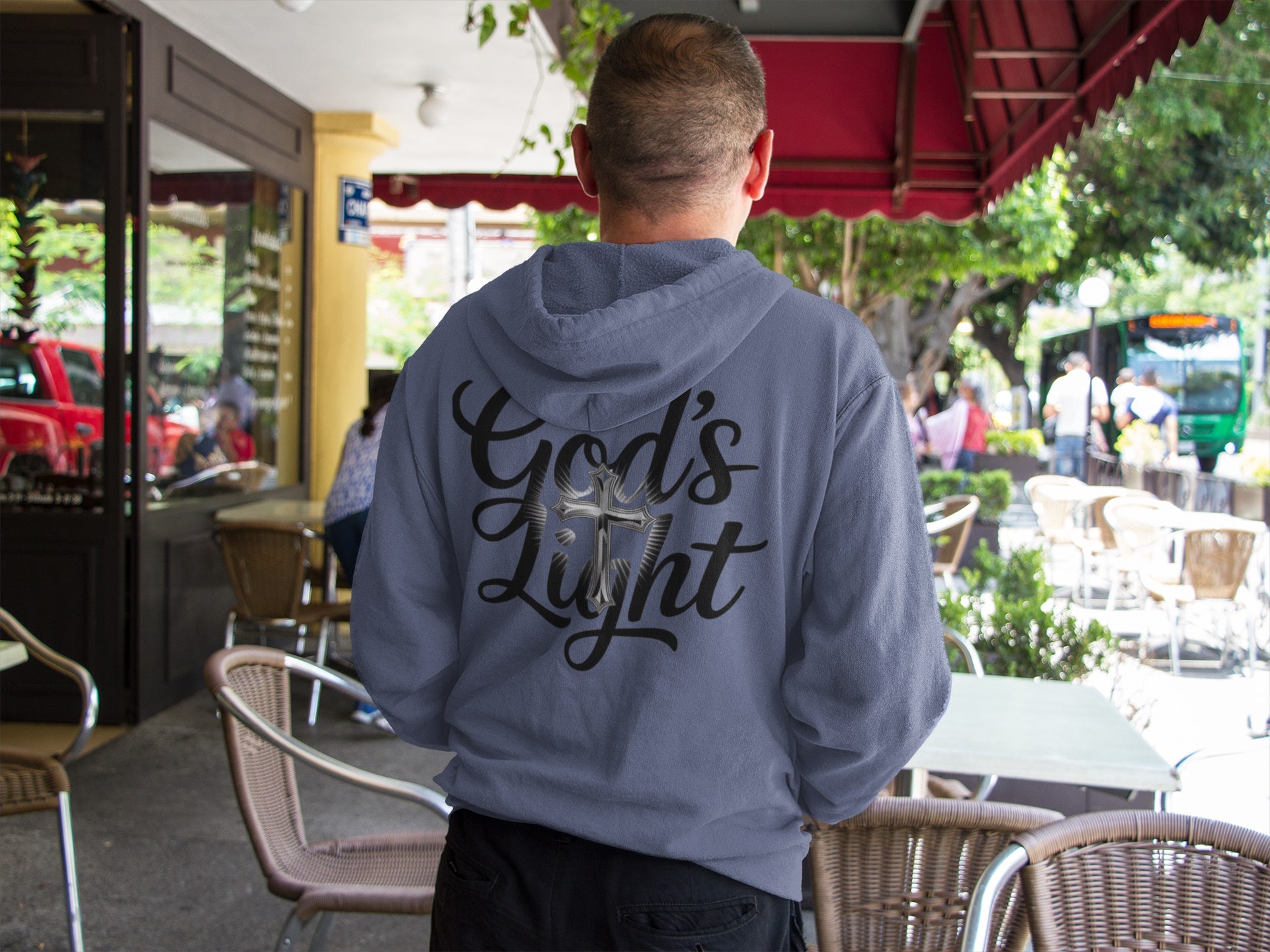 Divine Faith Armor™ GOD’S LIGHT hoodie with white script text and mirror-image cross design, faith-based Christian apparel for men, women, and youth Person wearing a hoodie with 'God's Light' text in an outdoor setting